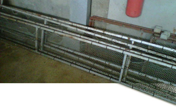 Cadre recouvert de grillage métallique fixé par des brides.