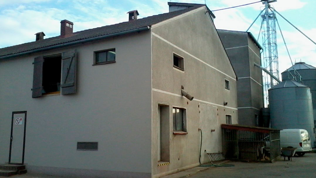 <p>Figure 1: B&acirc;timent d'engraissement; b&acirc;timent des truies reproductrices derri&egrave;re dans la partie sup&eacute;rieure droite; porte d'entr&eacute;e aux salles ext&eacute;rieures dans le mur.</p>
