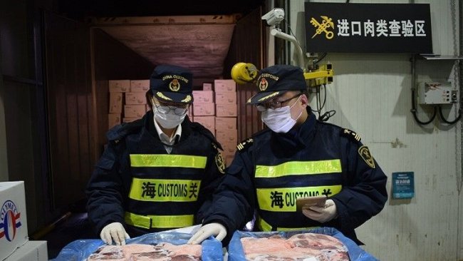 Les agents des douanes inspectent les produits de porc congelés importés. Crédit photo : Jiang Songqi